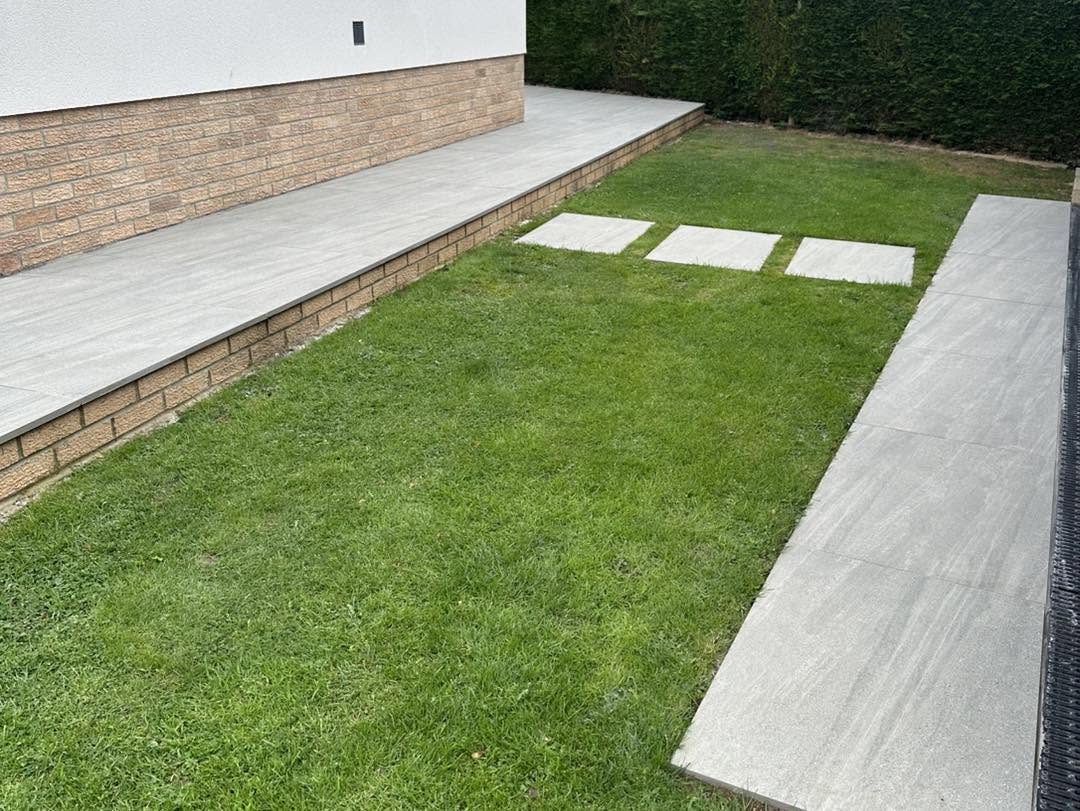 Raised porcelain terrace beside a lawn with three stepping stones
